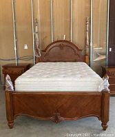 Front view of bed with headboard, footboard, side rails and mattress