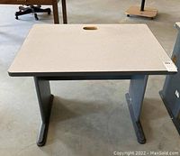 Laminate side table with light gray top and handle cutout in center, shown from front angle