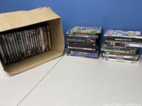 Box of DVDs standing in an open cardboard box, visible DVDs arranged in stacks next to the box