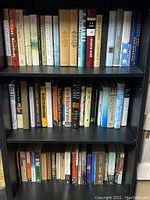 Full view of three shelves of books, showing full rows of titles on each shelf with no visible damage.