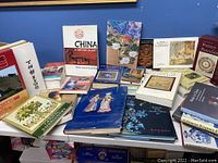 Books displayed on a table with varied covers related to Chinese and Japanese art and culture, some colorful with illustrations and photographs.