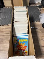 Photo showing comic books in a cardboard box, prominently featuring Beavis and Butt-Head comic at the front.