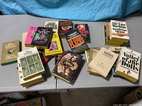 Overhead view of erotic paperback books arranged on a table showing covers and spines. Includes authors Xaviera Hollander, Jacqueline Susan, and other erotic novel titles.