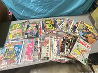 Overview of mixed comics collection displayed on table, showing different titles and colorful covers.