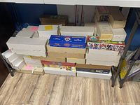 Wide view of stacked white and brown storage boxes with a Topps Collector Set box on top