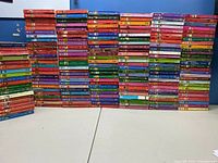 Photo showing a large stack of colorful paperback books arranged in rows, displaying their spines with a variety of titles from the Love INSPIRED romance series.