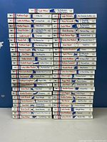 Photo showing the spines of 49 paperback Harlequin "Men Made in America" series books stacked side by side, titles and authors visible.