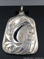 Close-up view of the eagle carved sterling silver pendant highlighting the deep carving and pierced areas.