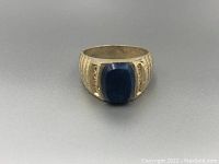 Front angled view of the lapis sterling silver custom ring showing the blue cabochon and engraved details on the band.