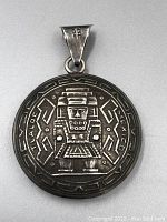Front side of the pendant showing the Mayan deity figure in relief with surrounding geometric motifs, marked with 'Mexico' on the edge.
