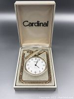 Cardinal pocket watch and gold-tone chain with fob in original box, showing dial and presentation condition.