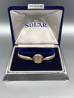 Front view of watch in original blue velvet-lined box with Solar logo inside lid.