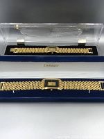 Two gold-tone wristwatches in open blue velvet-lined boxes with 'Dynasty' logo