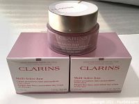 Two boxes and one jar of Clarins Paris Multi-Active Jour day cream showing front packaging.