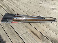 10 golf club shafts laid flat with grips attached, showing various brands including Ping, ALTA, ProForce, KBS, Titleist, and others