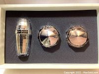 Photo of the 3-piece Shiseido Clé de Peau Beauté skincare set inside the box showing the three containers in black foam insert.