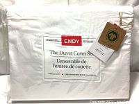 Image of ENDY branded packaging for The Duvet Cover Set showing 300 thread count, 100% organic cotton, King/California King size, alpine white color, with attached brand and organic certification tags.