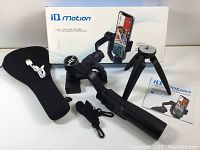Complete lot showing gimbal stabilizer, tripod, Bluetooth remote, carrying pouch, USB charging cable, instruction manual, and original box.