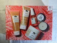 Front view of all 5 Origins Ginger Goodness products displayed on an orange box with white leaf patterns, with price tag visible.