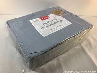 Photo of the blue ENDY sheet set sealed in clear plastic wrapping showing the complete folded package.