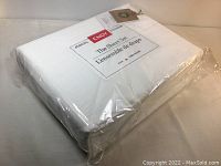 View of new sealed packaged white king size sheet set by ENDY, showing product label and packaging.