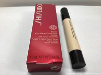 SHISEIDO Sheer Eye Corrector tube next to original red box, label visible with product name, shade 101, volume 3.8mL.