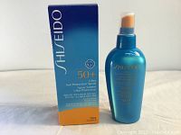 Photo shows the blue and orange box alongside the blue spray bottle with gold print showing product details and brand.