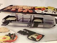 Photo of SWISSMAR Geneva raclette grill in use showing grilling of meats and vegetables on the reversible top.
