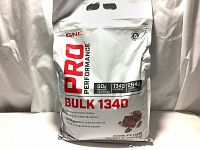 Front view of a large sealed 15lb bag of GNC Pro Performance Bulk 1340 Chocolate Fudge high-calorie mass gainer protein powder.
