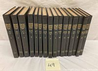 Full set of 16 Compton's Pictured Encyclopedias volumes arranged upright in order from A to Z with volume numbers visible.