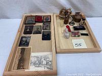 Wooden trays with antique tintype portraits, black-and-white photos, and assorted dollhouse figurines and miniature household accessories