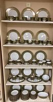 Full shelf display showing cups, saucers, plates arranged neatly on shelves.