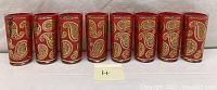 Front view of all 8 glasses, showing the red and gold paisley pattern.