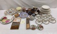 Overview of all porcelain items including plates, cups, saucers, creamers, teapot, salts and peppers, and silverware set.
