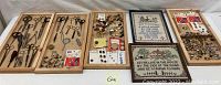 Wide view of lot showing wooden trays containing multiple pairs of scissors, buttons, crochet hooks, and framed needlework artworks