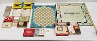 All items arranged on table showing the various game boxes, boards, cards, score pads, and pieces.