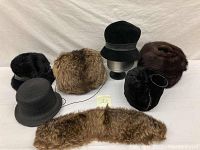 Overview of all fur hats and fur cuff accessories on white sheet. Shows different styles and colors.