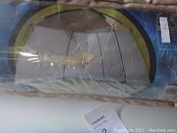 Photo of the tent in its original carrying bag showing a printed image of the assembled screen house tent and specifications.