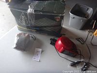 Photo of the Woods queen-size air mattress box, red electric air pump, and mosquito head net placed on a table.