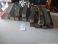 Thirteen boxed player piano rolls arranged on a table displaying wear on the boxes.