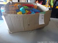 Full box of assorted Mega Bloks building blocks in various colors and shapes in cardboard box.