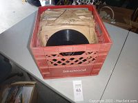 Red Silverwood crate filled with 78 RPM phonograph records in vintage paper sleeves, showing quantity and storage style.