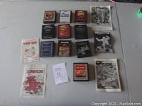 Full view of 10 Atari 2600 cartridges and accompanying original instruction booklets laid on a table, showing cartridge labels and booklets with game titles and artwork.