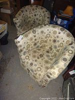 Two matching upholstered tub chairs in a beige circular geometric pattern with visible discoloration