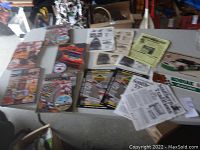 Overview of various Nascar Daytona 500 memorabilia on white table including programs, patches, magazines, and newspapers