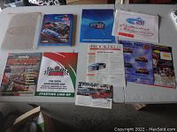 Top-down photo showing all NASCAR Daytona 500 related printed materials and patch on a table against a light background.