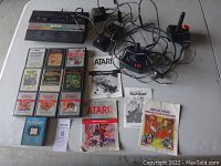 Overview of console, controllers, cartridges and manuals spread on table