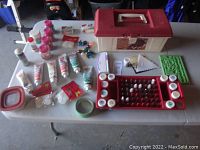 Overview of cake decorating tools and supplies arranged around carrying case on table including gel colors, decorating tips, bags, and tools