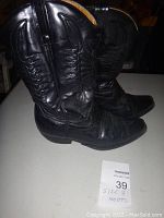 Side view of black leather cowboy boots showing stitching details and added rubber sole.