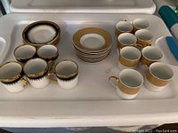 Photo showing complete sets with cups and saucers arranged on a tray.